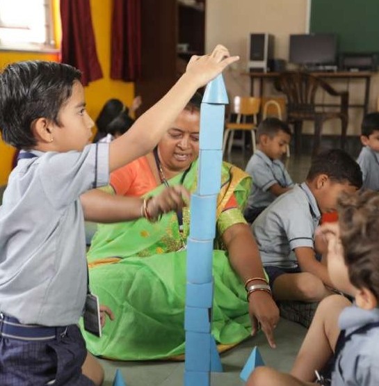 Kindergarten students learning with their teacher at Sri B. M. Patil Public School